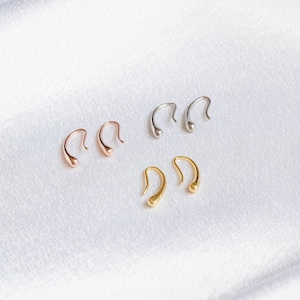 May include: A collection of three pairs of teardrop-shaped earrings in rose gold, silver, and gold tones. The earrings are displayed on a white, textured surface, showcasing their minimalist design and metallic finishes. These earrings are suitable for everyday wear.