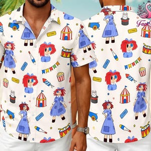 May include: A short-sleeved button-down shirt with a white base featuring a repeating pattern of rag dolls with red yarn hair, blue dresses, circus tents, popcorn buckets, magic hats with rabbits, drums, tickets, and fireworks. The logo Fam Fun is visible.