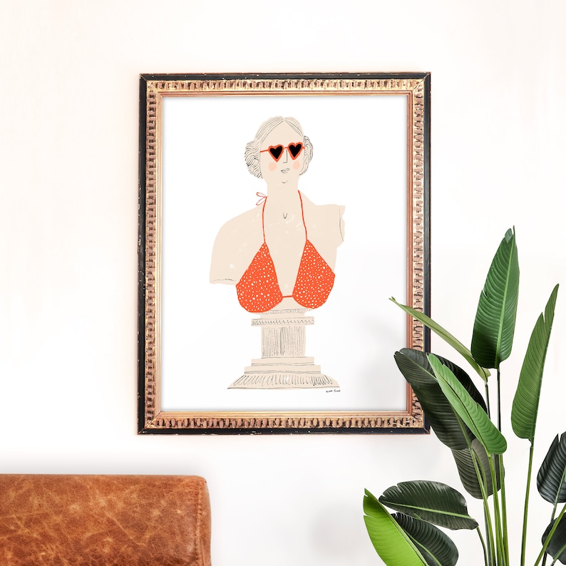 May include: A framed illustration of a bust sculpture wearing heart-shaped sunglasses and a red polka dot bikini top.