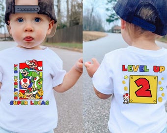 パーソナライズされたスーパーマリオの前後バースデーシャツ、幼児用カスタムTシャツ、マリオ幼児ギフト、スーパーTシャツ、マリオTシャツ、スーパーマリオベビーTシャツ