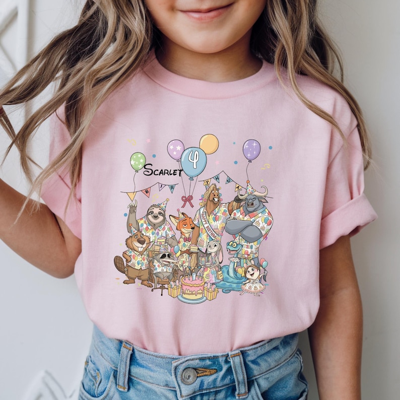 K&ouml;nnte beinhalten: Ein hellrosa T-Shirt mit einer Geburtstagsparty-Szene mit Zeichentierfiguren. Das Shirt hat den Namen "Scarlet" und die Zahl "4" sowie Luftballons und einen Kuchen. Das Shirt wird von einem Kind getragen.