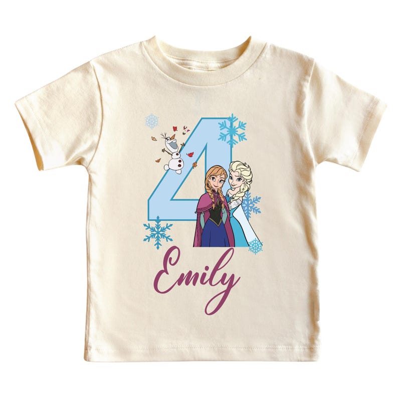 May include: A cream-colored t-shirt featuring a blue number 4 with illustrations of Anna, Elsa, and Olaf from Frozen. The name "Emily" is written in cursive below the number. The shirt is designed for a child.