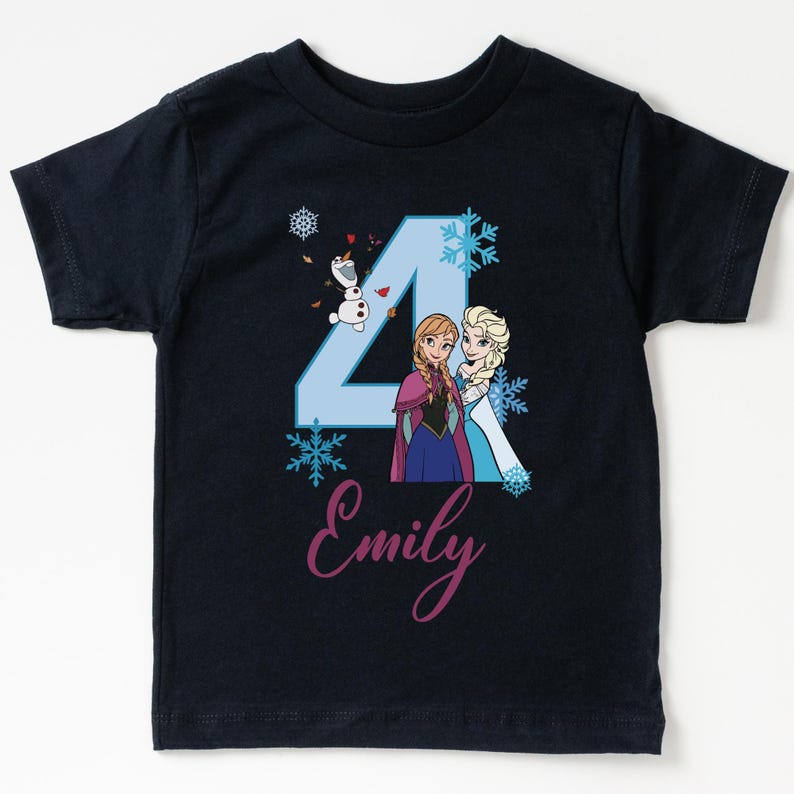 May include: Navy blue short-sleeve t-shirt featuring a light blue number 4 with Anna, Elsa, and Olaf from Frozen. The name "Emily" is written in cursive below the number. Snowflakes are scattered around the design.
