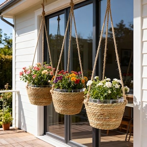 Puede incluir: Tres cestas colgantes de mimbre llenas de flores coloridas. Cada cesta está suspendida por una cuerda natural, creando una exhibición encantadora. Las flores incluyen flores rosas, rojas, amarillas y blancas, agregando un toque vibrante.