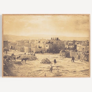 Puede incluir: Una fotografía en sepia de un pueblo indígena pueblo en el suroeste de los Estados Unidos. El pueblo está formado por edificios de adobe con techos planos y está rodeado de un paisaje seco y polvoriento.