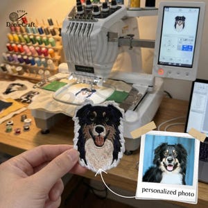 May include: An embroidered dog patch with black, brown, and white fur, held in front of an embroidery machine. The machine is displaying a dog image on its screen. A photo with the text "personalized photo" is also visible.