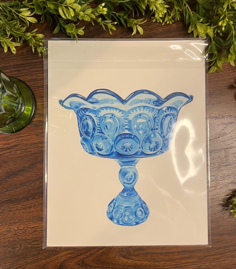 K&ouml;nnte beinhalten: Illustration einer blauen Glas-Fu&szlig;schale. Die Schale hat einen gewellten Rand und ein sich wiederholendes Muster aus Sternen und Kreisen. Das Kunstwerk befindet sich auf wei&szlig;em Hintergrund und ist in einer transparenten Kunststoffh&uuml;lle gesch&uuml;tzt.