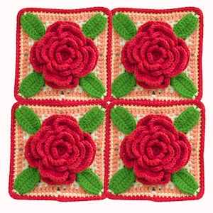 May include: Four crocheted squares, each featuring a red rose and green leaves. The squares have a peach-toned centre, a cream border, and a red outer edge. The squares are arranged in a 2x2 grid, showcasing a detailed floral design.