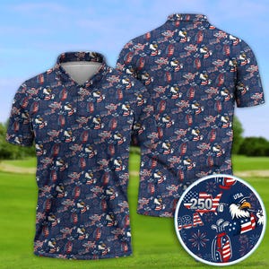 Puede incluir: Polo azul marino con un estampado repetido de banderas americanas, águilas, palos de golf y fuegos artificiales. El texto "250" y "USA" también están presentes. La camisa tiene cuello y mangas cortas.