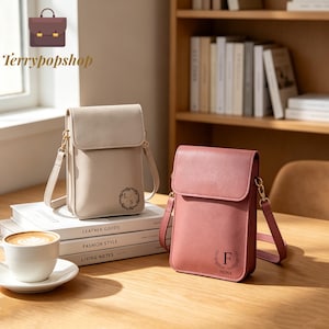 May include: Two vertical crossbody bags, one beige and one dusty rose, each featuring a flap closure, a thin shoulder strap, and a circular floral monogram detail. The beige bag displays the letters L S, while the rose bag features the letter F and the name Fiona.