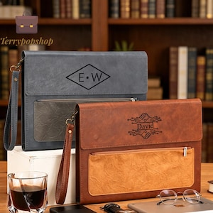 May include: Two rectangular document portfolios with wrist straps. The gray portfolio features a diamond logo with the letters E and W. The brown portfolio features a graphic of two hands shaking with the name David printed in the center.