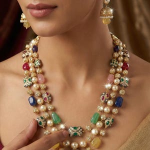 May include: A multi-strand necklace and matching earrings featuring pearls, colorful gemstones, and gold accents. The necklace has layers of pearls and gemstones in various colors, including red, green, blue, and yellow. The earrings have a similar design.