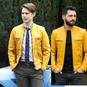 May include: Two men in yellow leather jackets. The jackets feature a zip-up front, two chest pockets, and a stand-up collar. One man is wearing a white shirt and a patterned tie. The other man is wearing a black shirt.