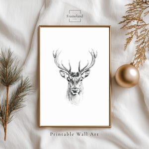 May include: A framed black and white print of a deer's head with large antlers. The artwork is in a gold frame and is labeled "Printable Wall Art". The image is set against a white background with decorative elements.