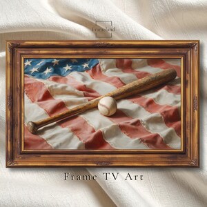 Könnte beinhalten: Ein rechteckiger Holzrahmen mit einem Druck eines hölzernen Baseballschlägers, der auf einer gefalteten amerikanischen Flagge liegt, mit einem Baseball in der Mitte. Der Text Frameland ist oben und Frame TV Art ist unten zu sehen.