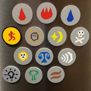 May include: A collection of round, gray magnets with various colorful graphic designs. The designs include a red flame, a blue water drop, a yellow running figure, a skull and crossbones, and other abstract shapes.