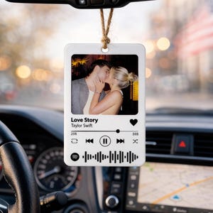 Peut inclure: Désodorisant de voiture blanc avec une photo d'un couple s'embrassant. Le design imite un lecteur de musique Spotify, affichant la chanson "Love Story" de Taylor Swift. Suspendu à une ficelle marron.