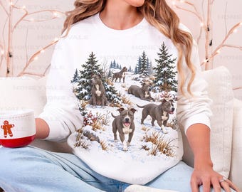 May include: A white long-sleeve sweatshirt featuring a graphic print of four grey pit bull dogs in a snowy forest setting with pine trees. The sweatshirt has a crew neckline and ribbed cuffs. The text WHITE is printed in the top left corner.