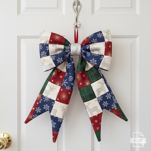 May include: A large, decorative bow with a patchwork design, perfect for holiday decor. The bow features squares of red, green, blue, and cream fabric, adorned with snowflakes, deer, and gold starbursts. A silver ribbon wraps the center, and a red ribbon hangs from the top.