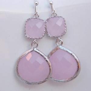 May include: A pair of silver dangle earrings with two pink faceted glass stones on each earring.