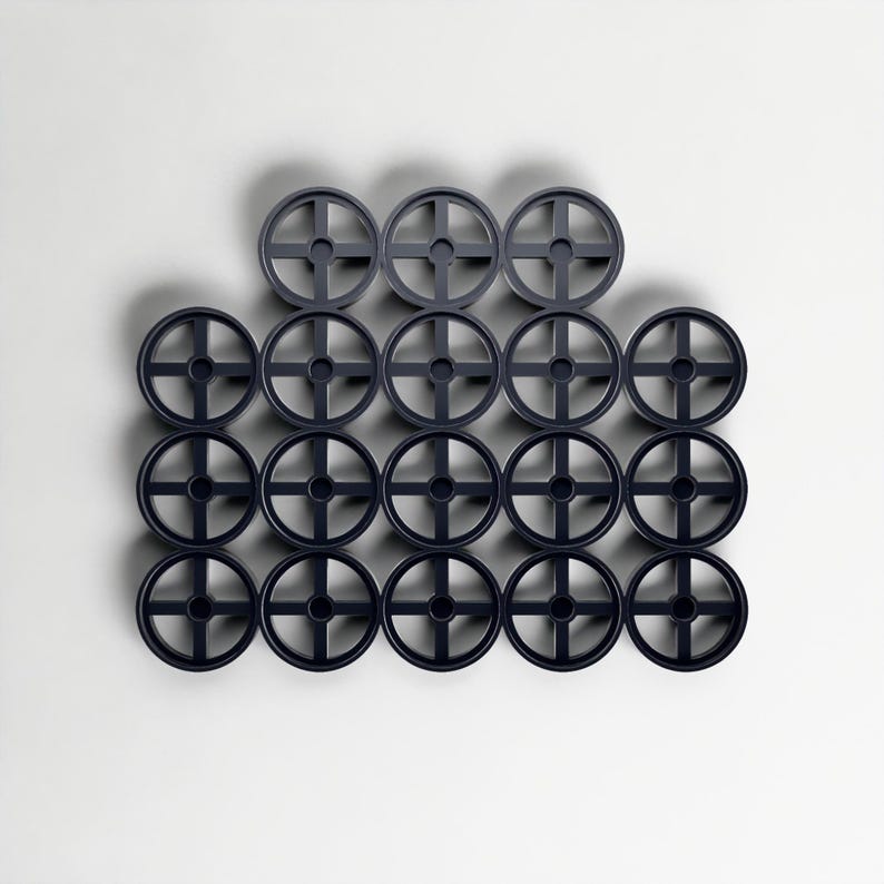 May include: A collection of twenty dark blue circular objects, each featuring a cross-shaped design at the centre. They are arranged in a grid pattern against a white backdrop. The objects appear to be made of plastic, and are evenly spaced.