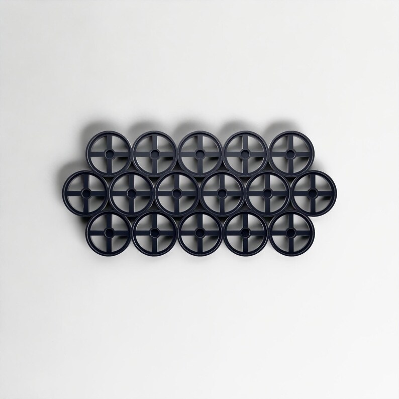 Pode incluir: Uma cole&ccedil;&atilde;o de dezesseis objetos circulares azul escuro com um design em forma de cruz no centro, dispostos em um padr&atilde;o de grade contra um fundo branco. Os objetos parecem ser feitos de pl&aacute;stico ou material semelhante. Di&acirc;metro de cerca de 5 cm.