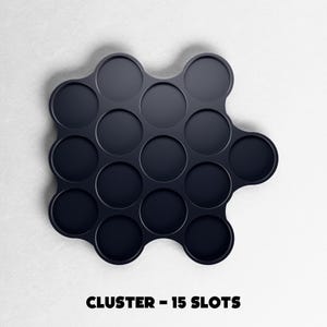 May include: A dark navy blue cluster organizer with 15 circular slots. The product is on a white background. The text "CLUSTER - 15 SLOTS" is printed in bold, black letters at the bottom of the image.