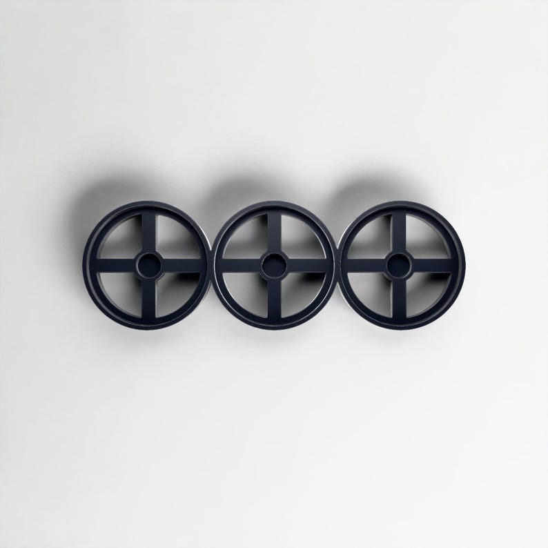 Pode incluir: Tr&ecirc;s decora&ccedil;&otilde;es de parede circulares azul marinho com um design em forma de cruz dentro de cada c&iacute;rculo. Os objetos est&atilde;o espa&ccedil;ados uniformemente e dispostos horizontalmente contra um fundo branco, projetando uma sombra sutil.