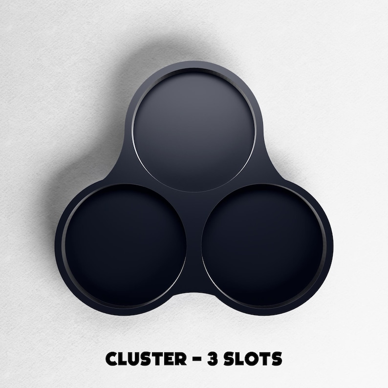 May include: A dark navy blue cluster with three circular slots. The object is made of a smooth material and is set against a white background. The text "CLUSTER - 3 SLOTS" is displayed at the bottom of the image.