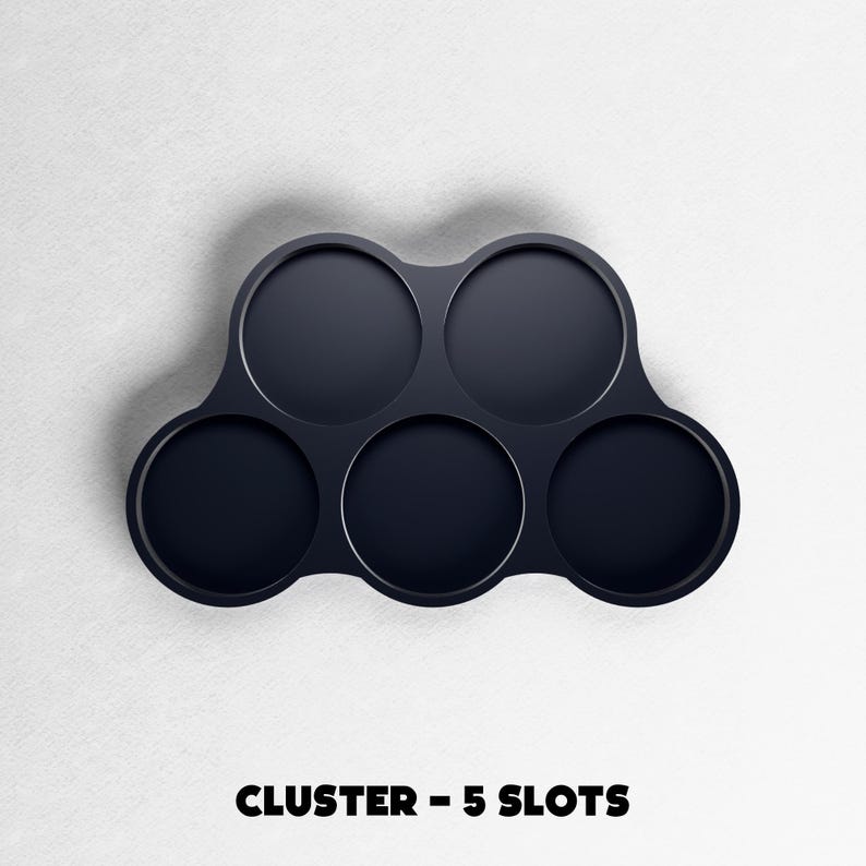 May include: A dark navy blue cluster with five circular slots. The product is designed to hold multiple items. The text "CLUSTER - 5 SLOTS" is printed at the bottom of the image.