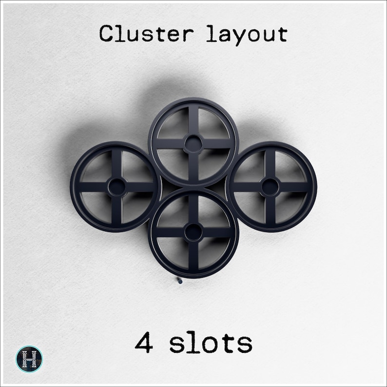 May include: A cluster of four dark gray, circular objects with cross-shaped designs, arranged in a square formation. The text "Cluster layout" and "4 slots" are displayed above and below the objects, respectively.