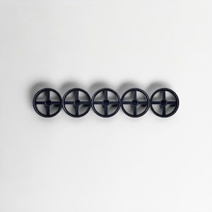 Pode incluir: Cinco ganchos de parede circulares azul marinho dispostos horizontalmente. Cada gancho apresenta um design em forma de cruz dentro do c&iacute;rculo. Os ganchos s&atilde;o montados em um fundo branco liso, criando uma est&eacute;tica minimalista.