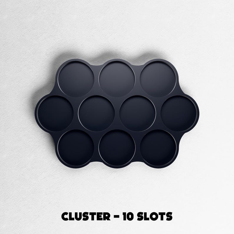 May include: A dark navy blue cluster tray with ten circular slots. The tray has a unique, curved shape and is set against a white background. The text "CLUSTER - 10 SLOTS" is printed in bold, black letters at the bottom.