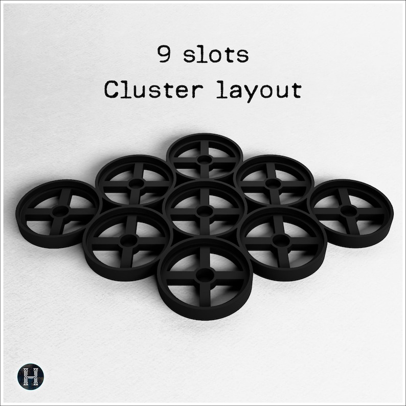 May include: Nine black, circular objects with a cross-shaped design are arranged in a cluster layout. The text "9 slots Cluster layout" is displayed above the objects. The objects are on a white background.
