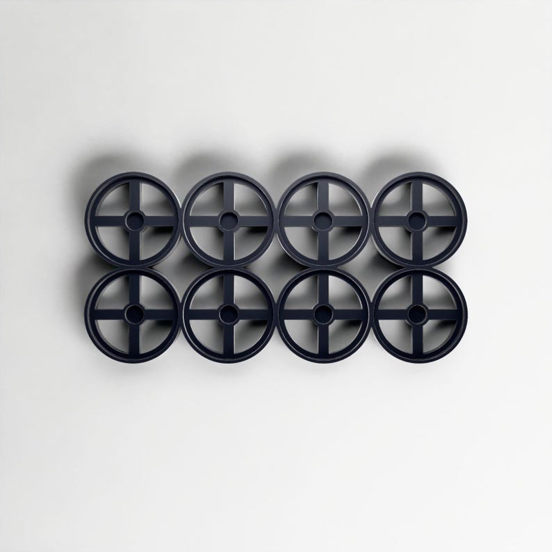 May include: Eight dark blue, circular objects with a cross-shaped design inside, arranged in two rows of four. The objects are evenly spaced against a white background, creating a symmetrical pattern. The design is simple and modern.