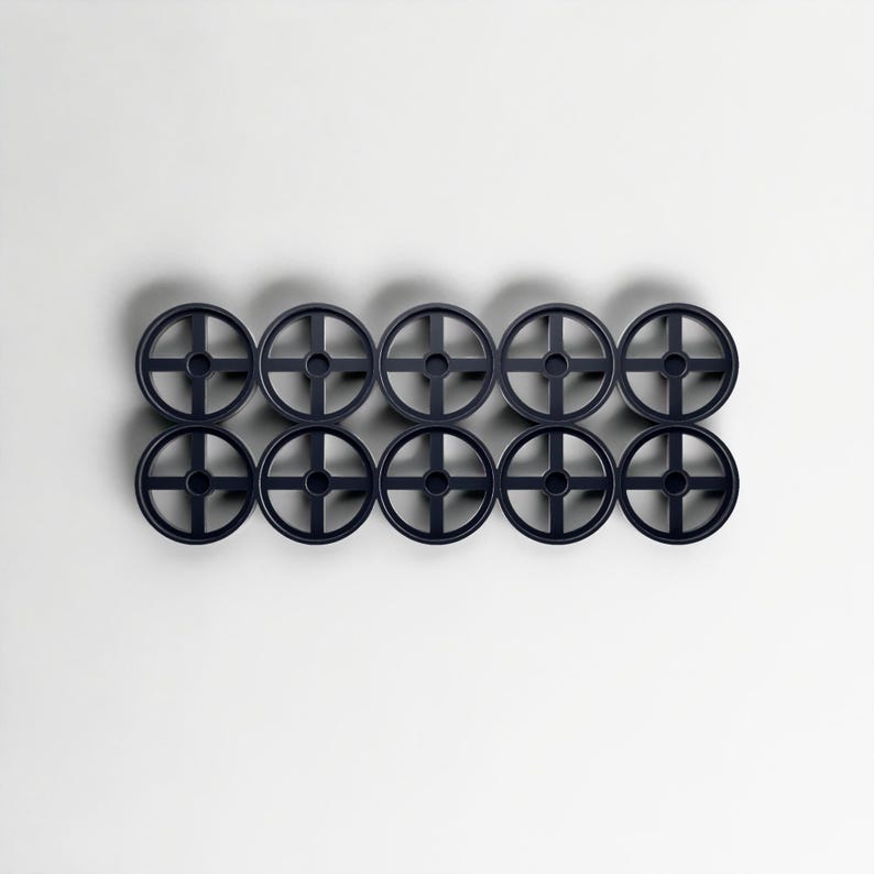 May include: Ten dark blue, circular objects with a cross-shaped design in the centre, arranged in two rows of five. The objects are evenly spaced against a white background, creating a symmetrical pattern.
