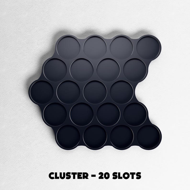 May include: A dark navy blue cluster tray with 20 circular slots. The tray has a unique, curved shape and is designed to hold small items. The text "CLUSTER - 20 SLOTS" is printed in black at the bottom of the image.