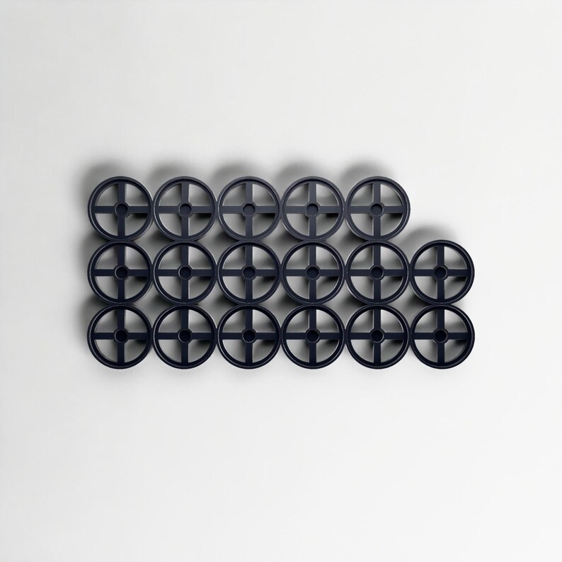 May include: Sixteen dark blue wheel-shaped objects arranged on a white background. Each wheel has a central hub and four spokes. The objects are evenly spaced, forming a pattern. The wheels are all the same size and shape.