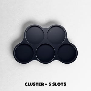 May include: A dark navy blue cluster with five circular slots. The product is designed to hold multiple items. The text "CLUSTER - 5 SLOTS" is printed in bold, black letters at the bottom of the image.