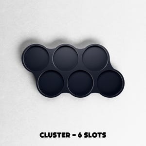 May include: A dark navy blue cluster with six circular slots. The slots are arranged in a curved pattern. The text "CLUSTER - 6 SLOTS" is printed in bold, black letters at the bottom of the image.