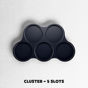 May include: A dark navy blue cluster with five circular slots. The product is designed to hold multiple items. The text "CLUSTER - 5 SLOTS" is printed at the bottom of the image.