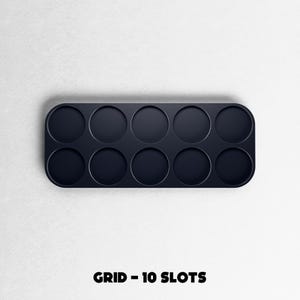May include: A dark navy blue grid with ten circular slots, perfect for organizing small items. The text "GRID - 10 SLOTS" is printed in black at the bottom of the image. The grid has rounded corners and is set against a white background.