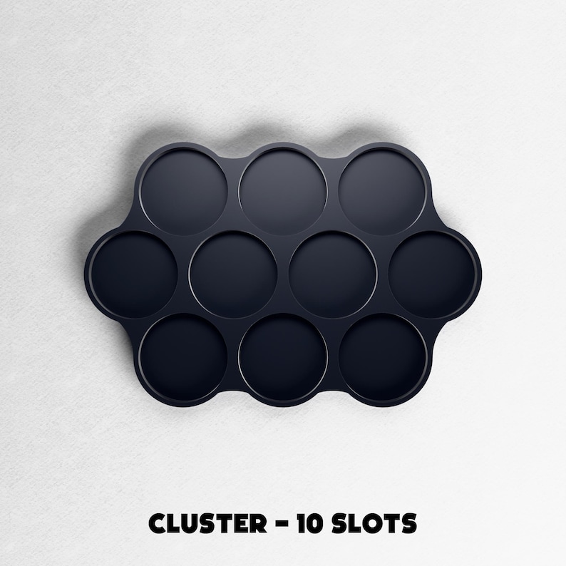 May include: A dark navy blue cluster tray with ten circular slots. The tray is on a white background. The text "CLUSTER - 10 SLOTS" is printed in black at the bottom of the image.