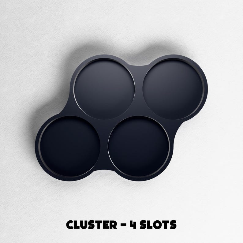 May include: A dark navy blue, four-slot cluster tray. The tray has four circular indentations connected by a curved design. The text "CLUSTER - 4 SLOTS" is at the bottom of the image.