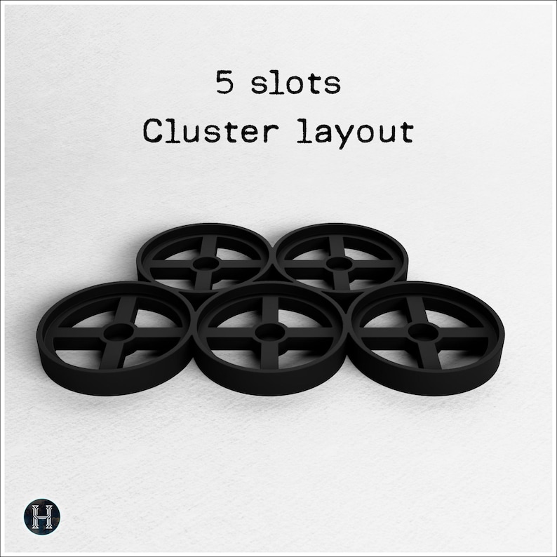 May include: Five black circular objects with a cross-shaped design in the center are arranged in a cluster layout. The text "5 slots" and "Cluster layout" are above the objects.