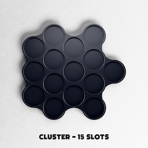 May include: A dark navy blue cluster organizer with 15 circular slots. The organizer is on a white background. The text "CLUSTER - 15 SLOTS" is printed in black at the bottom of the image.
