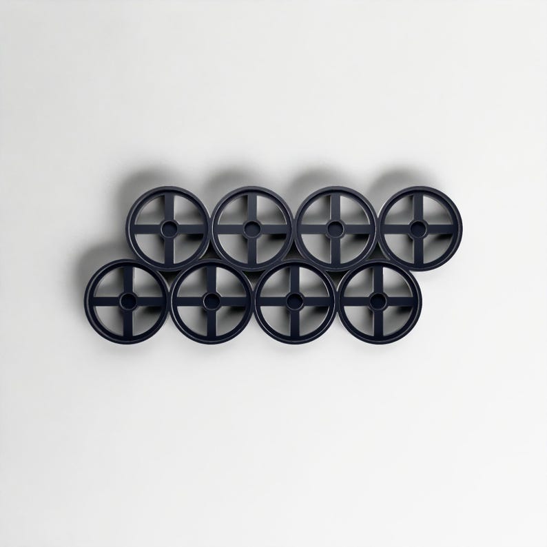 Pode incluir: Oito objetos circulares azul marinho com um design em forma de cruz no centro, dispostos em um padr&atilde;o escalonado. Os objetos s&atilde;o espa&ccedil;ados uniformemente contra um fundo branco, criando uma est&eacute;tica minimalista.