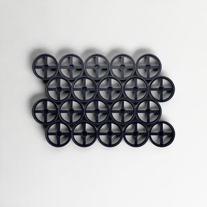 Pode incluir: Arranjo de vinte e um objetos circulares azuis escuros, cada um com um design em forma de cruz no centro. Est&atilde;o uniformemente espa&ccedil;ados contra um fundo branco, criando um padr&atilde;o.