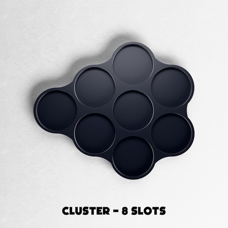 May include: A dark navy blue cluster-shaped organizer with eight circular slots. The text "CLUSTER - 8 SLOTS" is printed in bold, black letters at the bottom of the image. The organizer is set against a white background.