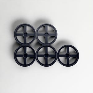 May include: Six dark blue circular objects with a cross-shaped design, arranged in a geometric pattern against a white background. The objects are evenly spaced. The design is modern and minimalist.